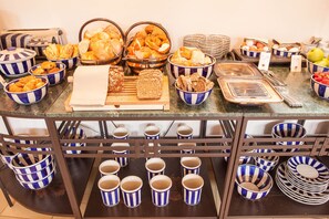 Une table de buffet garnie de divers plats et d’ustensiles.