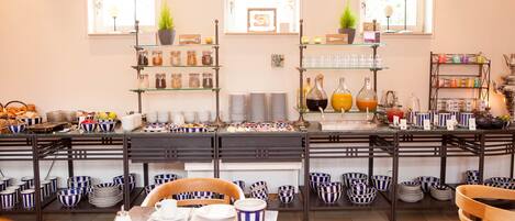 A breakfast buffet with various food items and beverages, arranged on shelves and tables.