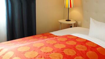 A hotel room with a bed, a round table, and a lamp.