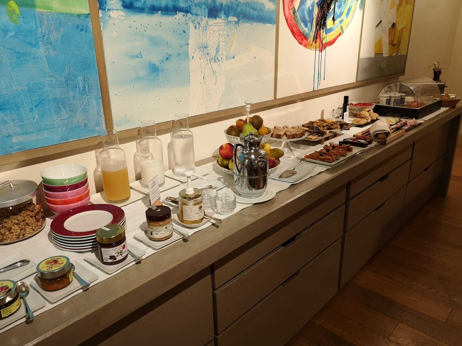 A buffet with various food items, condiments, and beverages.