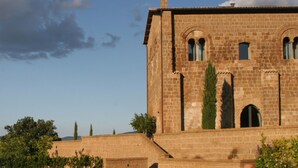 A stone building with a pool in front.