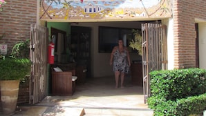 A building entrance with a colorful mural and a sign that reads "California." - Pousada California (Aracati)