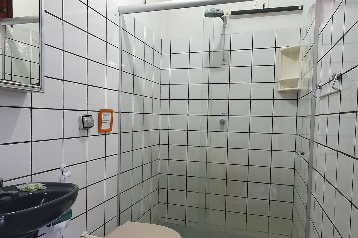 A small bathroom with a toilet, sink, and shower.
