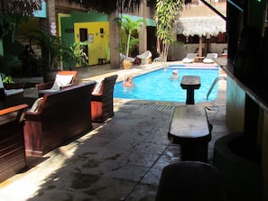 Un área de piscina con sillones de descanso y una piscina pequeña.