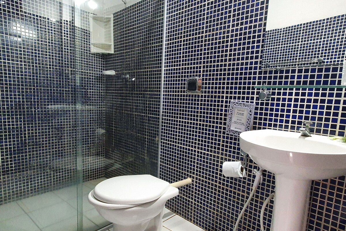 Une salle de bain comprenant des toilettes, un lavabo et un espace douche.