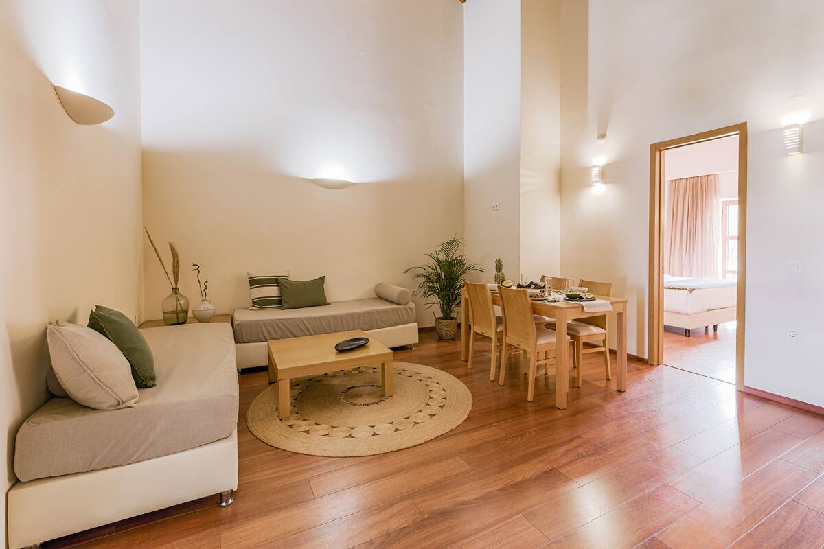 Una sala de estar moderna con un sofá, una mesa de centro, una mesa de comedor y sillas.
