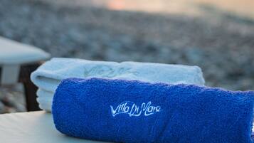 A towel with a logo on a surface near a body of water during sunset.