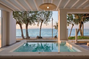 Zona de piscina con vistas al mar y a los árboles.
