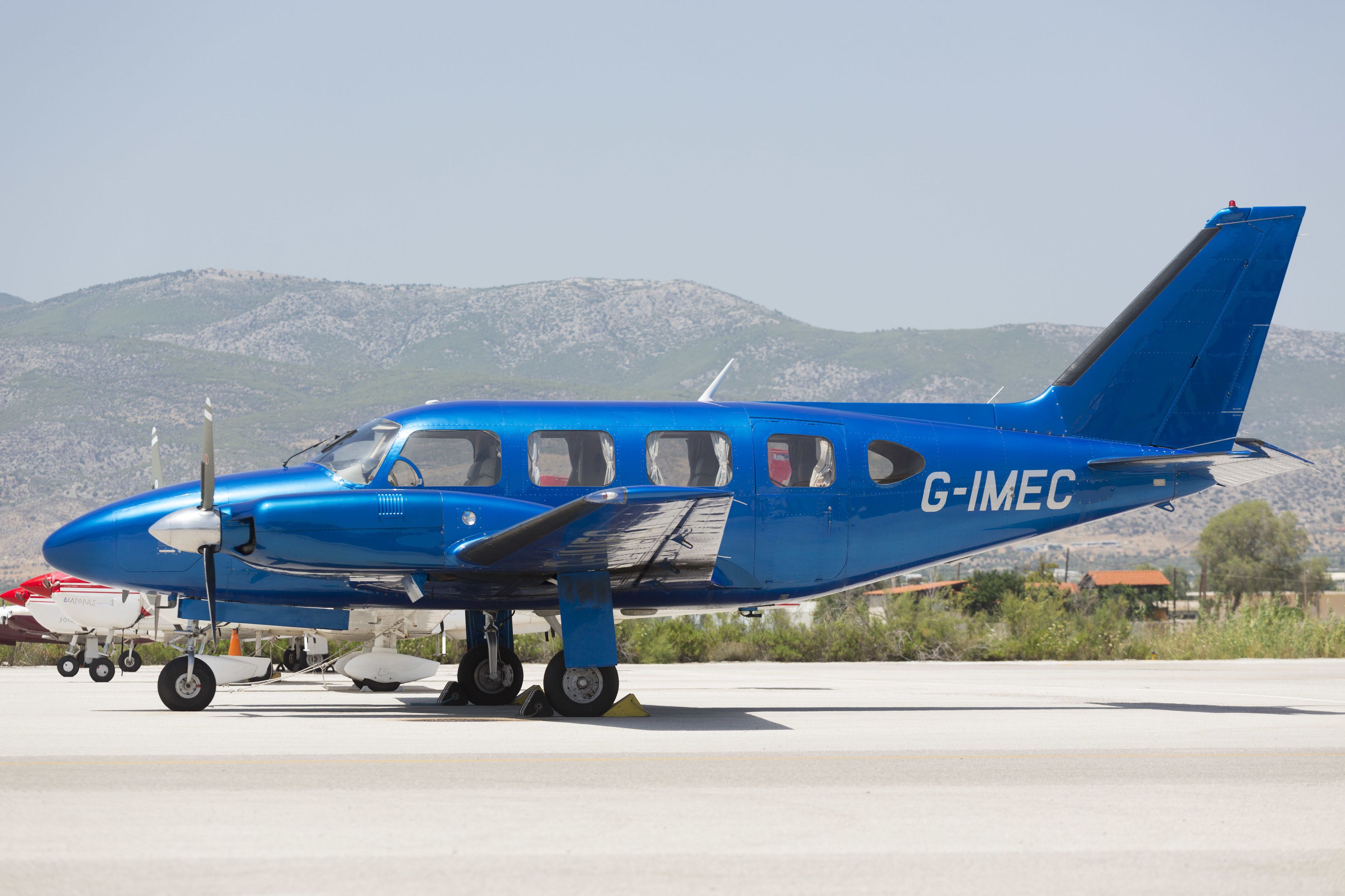 Un pequeño avión azul con el código de registro G-IMEC en una plataforma.