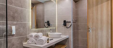 A modern bathroom with a toilet, sink, and mirror.