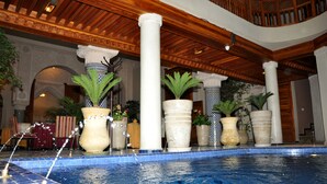 An indoor swimming pool with multiple columns and potted plants. - Riad Andalib (Fes)