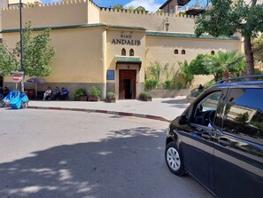 Un edificio con un letrero que dice "Riad Andalif" y una entrada protegida por una reja.