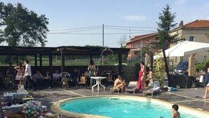 Un área junto a la piscina con una mesa de buffet, sillas de descanso y una pileta.