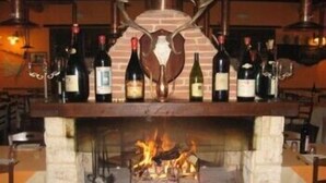 Una chimenea con un revestimiento de ladrillo y una repisa que exhibe botellas de vino.