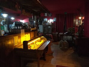 A bar area with a counter, a display case with bottles, and a seating area with a table and chairs. - Hotel Il Dito e la Luna (Ripa Teatina)