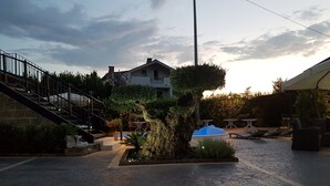 Un patio con escaleras, un árbol y mobiliario exterior.