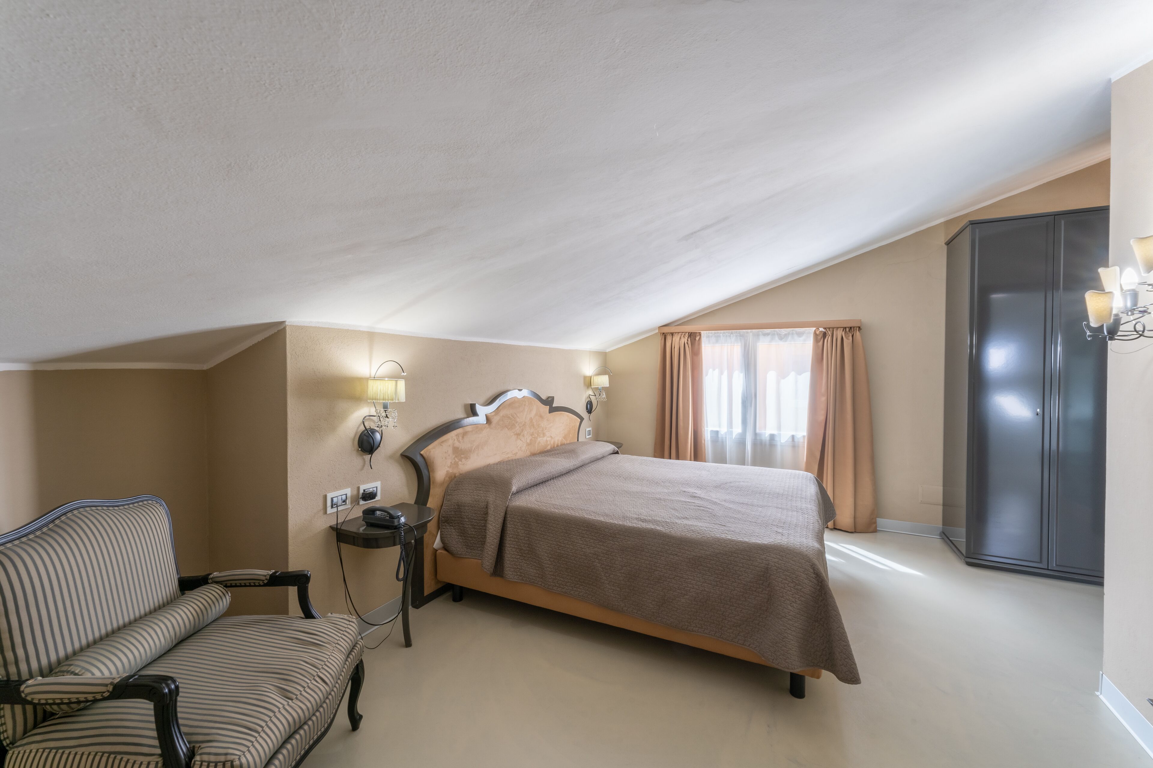 Ett hotellrum med en säng, en stol, ett skrivbord och en garderob.