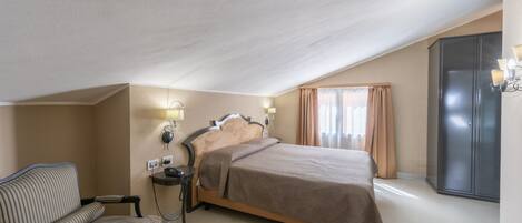 Ett hotellrum med en säng, en stol, ett skrivbord och en garderob.