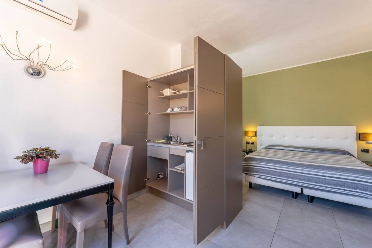 Un dormitorio pequeño con cama, escritorio y armario.