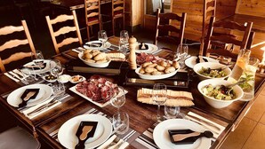 A dining table set with plates, cutlery, glasses, and various food items.