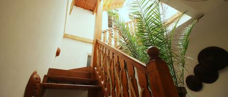 A wooden staircase with a handrail, leading to an upper level.