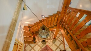 Eine Holztreppe mit einem gemusterten Teppich und einer hängenden Laterne.