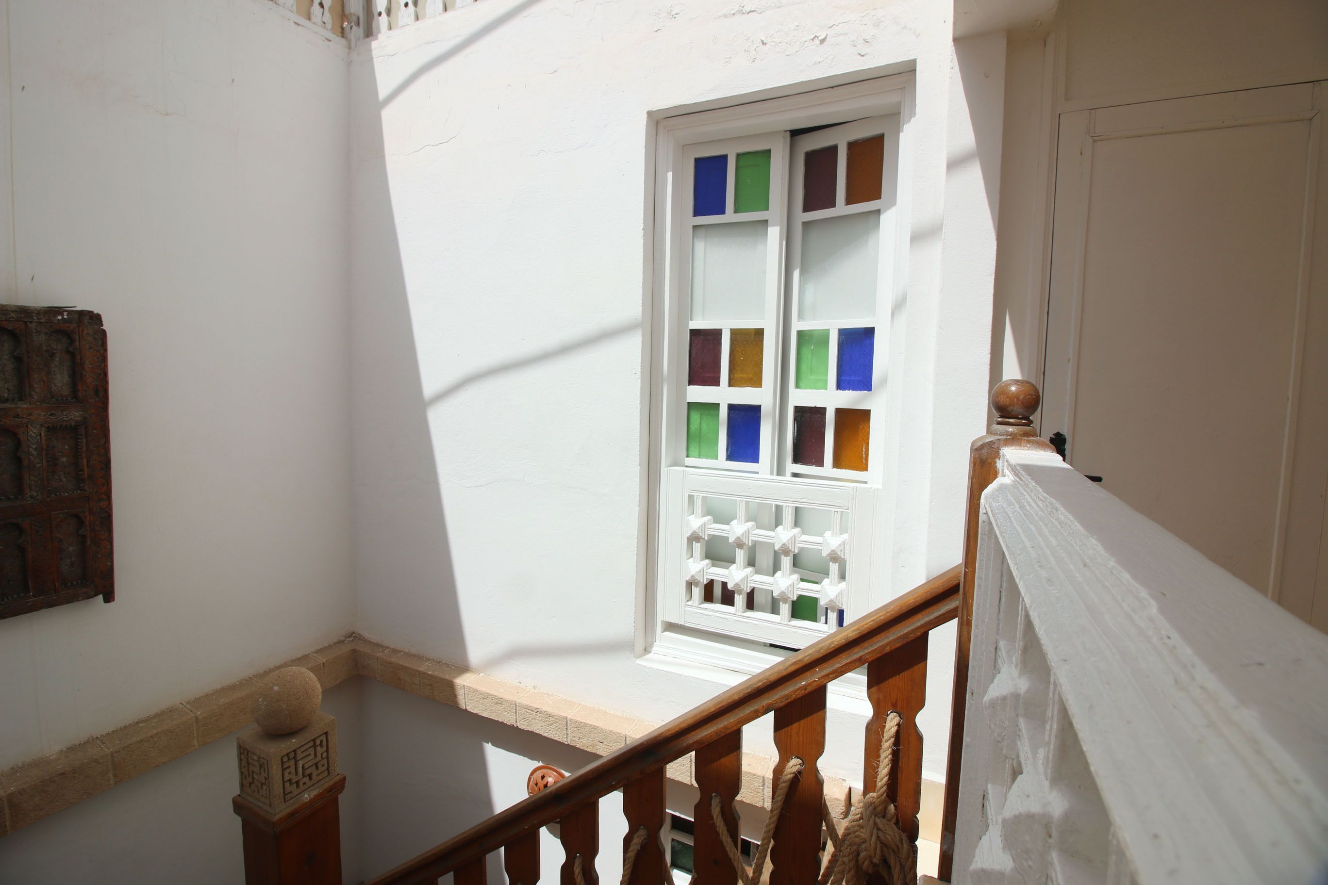 A staircase with a wooden handrail and a white balustrade.