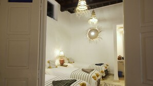 Ein Schlafzimmer mit zwei Betten, einer Chandelüster und einem Nachttisch mit Lampe.