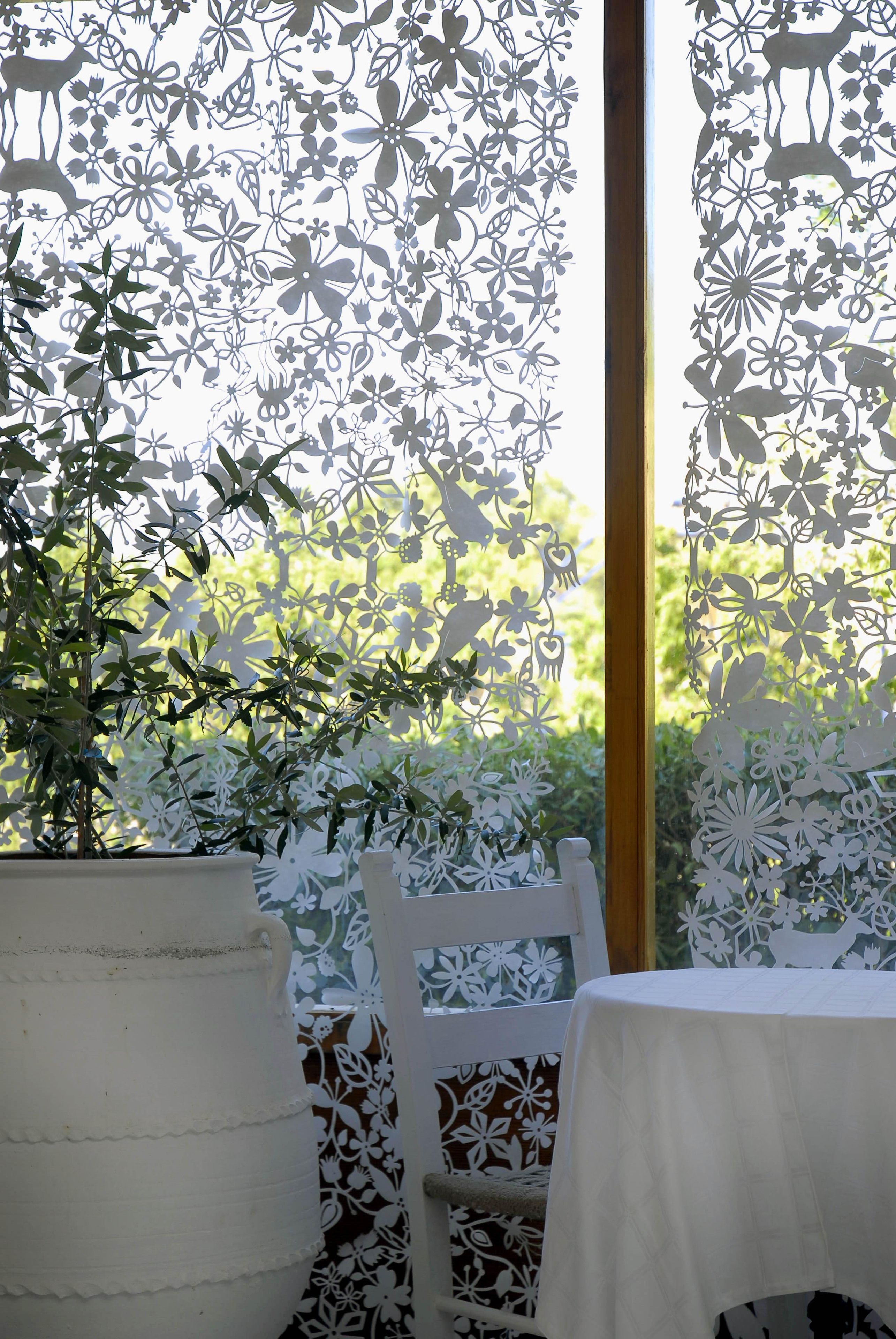 A room with a white table, a chair, and a potted plant.