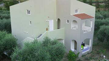 Un immeuble à plusieurs étages, doté d’une façade vert clair, de nombreux balcons et d’un escalier menant aux étages supérieurs.