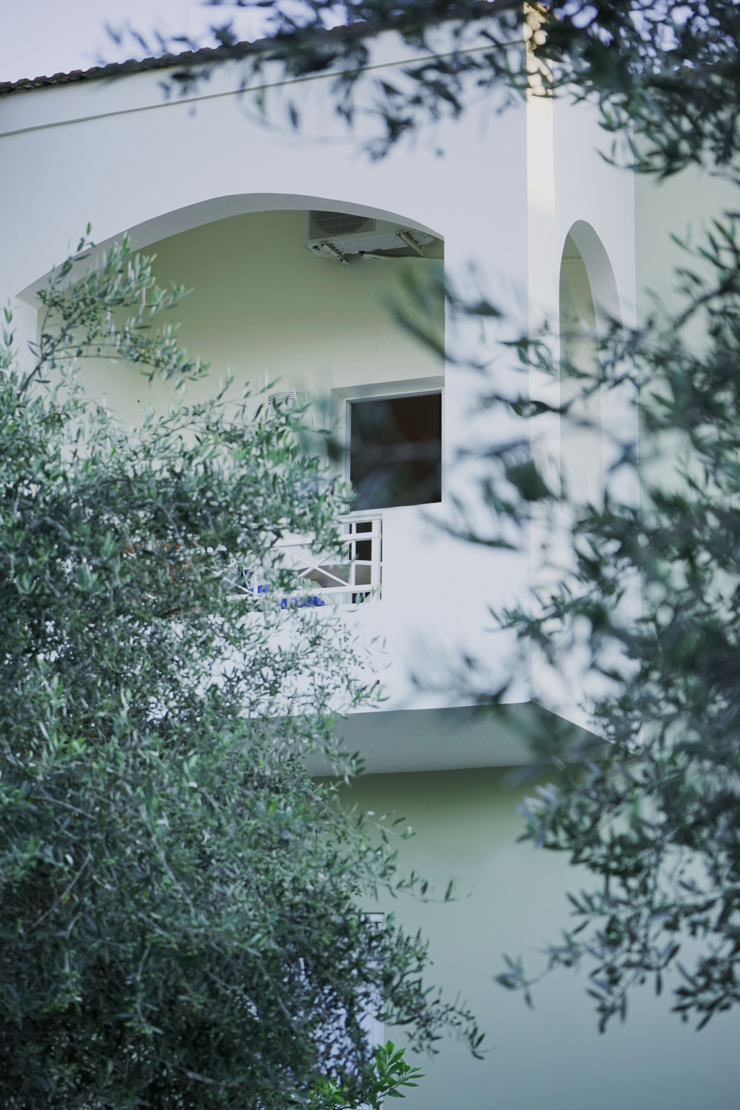 Ein Gebäude mit einem gebogenen Balkon und einem Fenster.