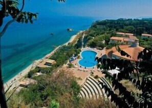 A resort with a large swimming pool, a beach, and lush greenery. - Villaggio Marco Polo (Ricadi)