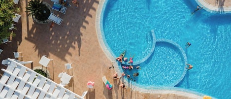 An aerial view of a swimming pool with lounge chairs and a poolside area.