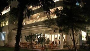Un hotel de varios pisos con un patio central, que cuenta con una zona de estar y una piscina.