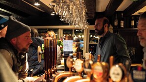 Zona de bar con múltiples grifos de cerveza y un cantinero.