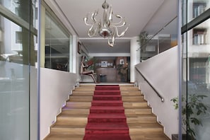 A modern staircase with a red carpet, wooden steps, and a chandelier. - Park Suites Hotel Boutique Hotel (Casablanca)