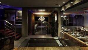 Un hall d’hôtel avec un escalier, un lustre et un comptoir d’accueil.