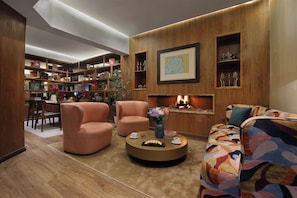 A cozy living room with a fireplace, comfortable seating, and a well-organized bookshelf. - Park Suites Hotel Boutique Hotel (Casablanca)