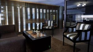 Un salon moderne avec un canapé, deux fauteuils et une table basse.