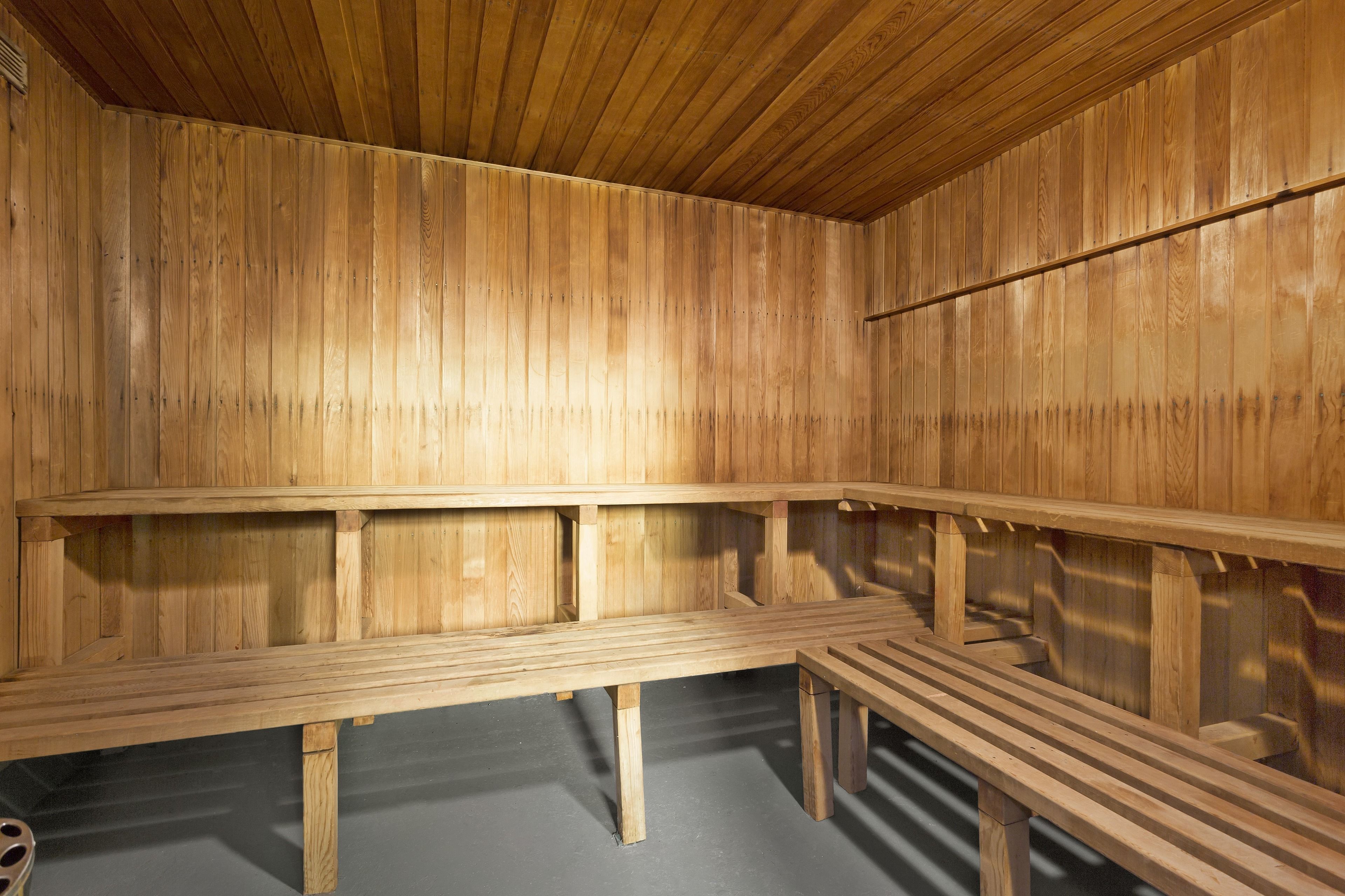A sauna room with wooden benches and a sloped ceiling.