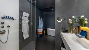 A modern bathroom with a glass-enclosed shower, a white bathtub, and a vanity with a mirror.