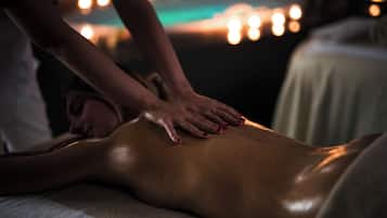 Eine Massageanwendung, wobei eine Person bäuchlings auf einer Massageliege liegt.