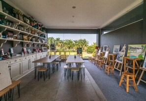 Enjoy a room with a high ceiling, large windows, and a central dining area.