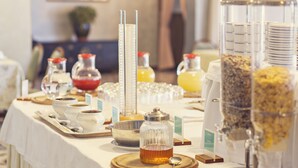 A buffet table with various food and drink dispensers, including a clear glass jar with a metal lid and a metal container with a handle. - Hotel Tre Laghi (Nebbiuno)
