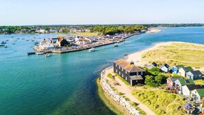 A coastal town with a marina, houses, and a sandy beach. - The Fisherman's Haunt (Christchurch)