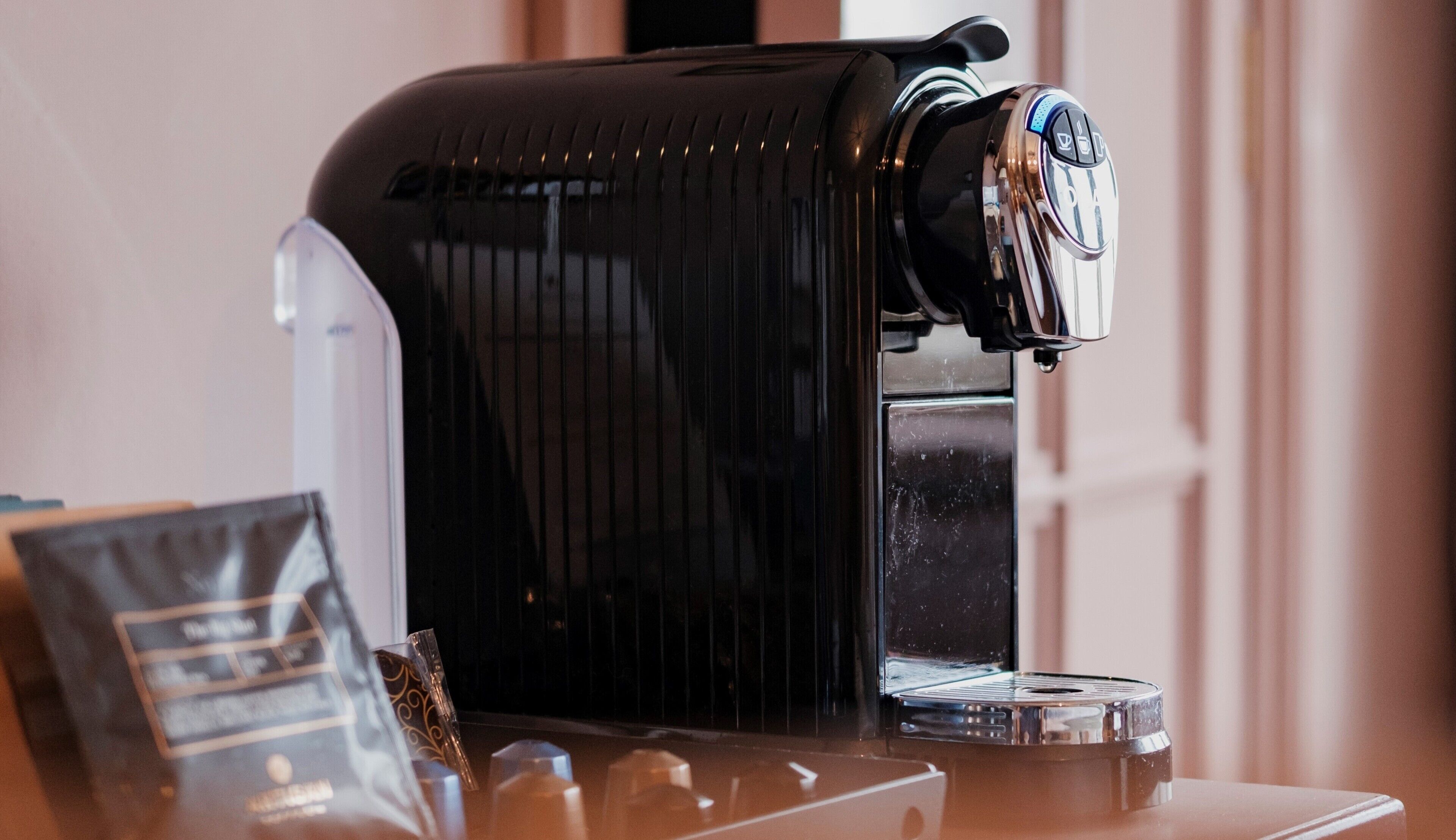En kaffemaskine med digitalt display og vandbeholder.