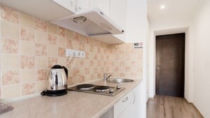 A modern kitchen with a kettle, a sink, and a stove. - Odessa Rent Service Apartments at Sea-side (Odesa)