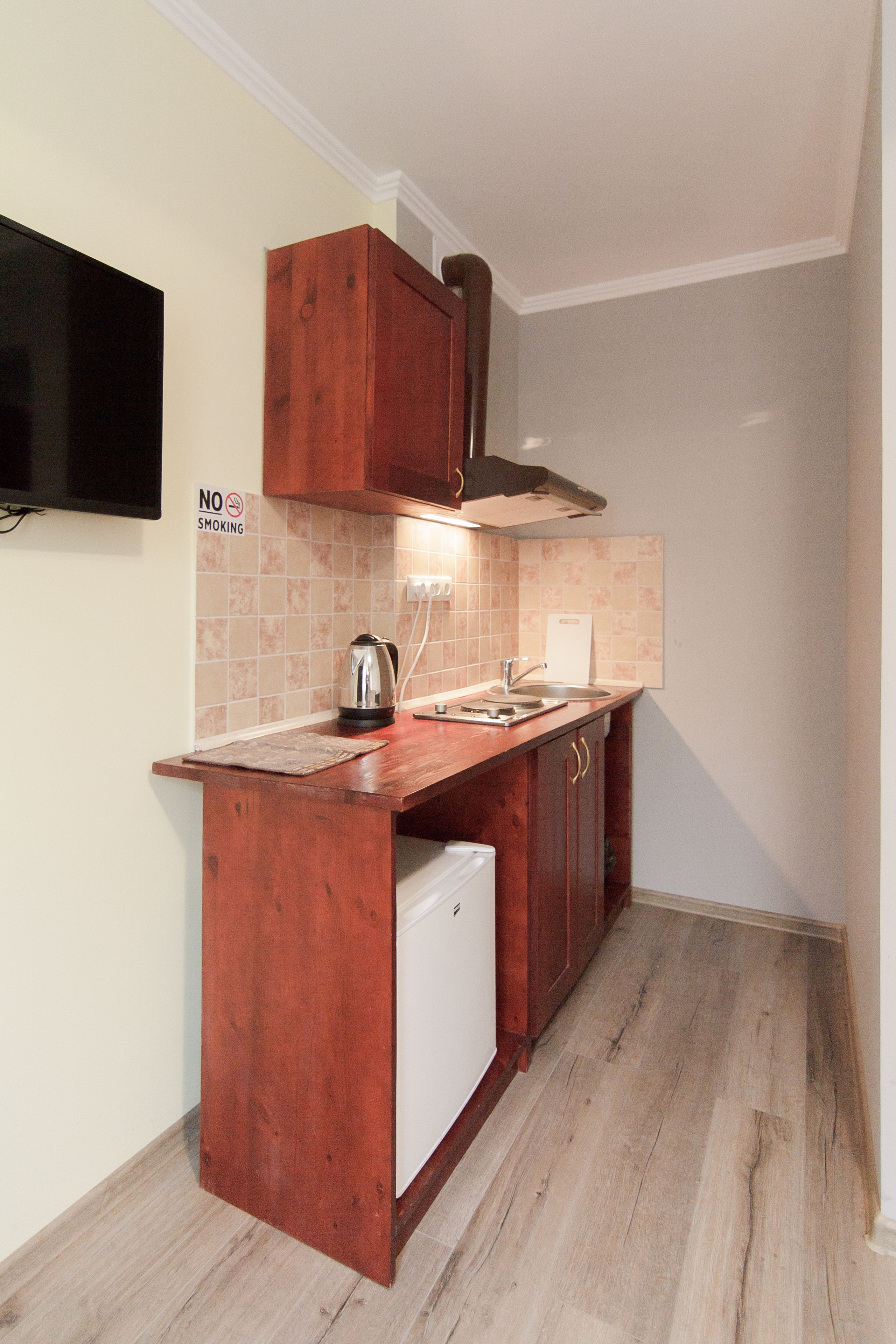 A compact kitchen with a built-in refrigerator, a sink, and a stove.