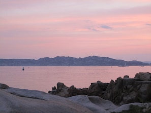 A coastal landscape with rocky formations and a calm sea.