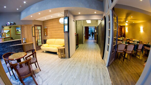 Un interior moderno con comedor, sofá y una pequeña mesa con sillas.